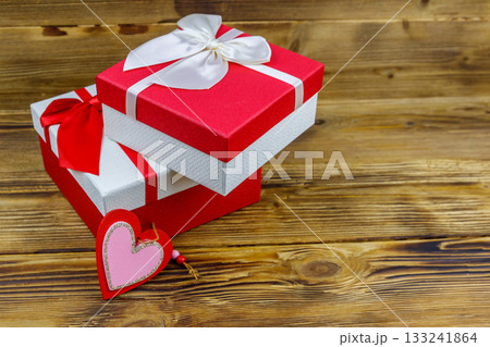 Gift boxes and red heart on a wooden background. Valentine's Day concept Gift boxes and red heart on a wooden background. Valentine's Day concept 133241864