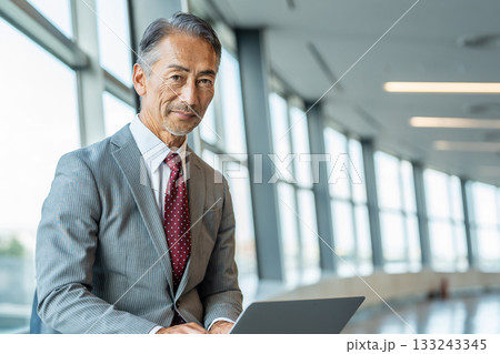 ノートパソコンを操作するシニアのビジネスマン 133243345