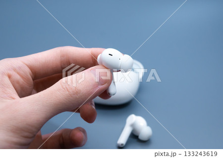 Hand Removing White Earbud from Case Hand Removing White Earbud from Case 133243619