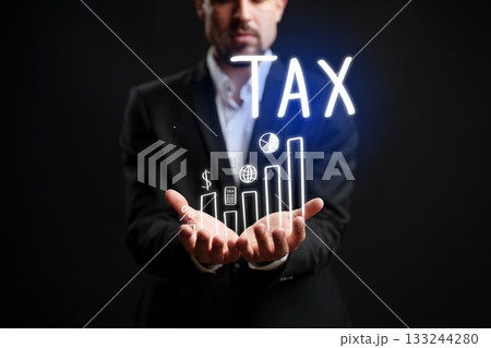 Businessman holding graphs and tax symbols in a creative presentation 133244280