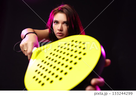 Model poses with bright yellow kitchen tool in artistic lighting Model poses with bright yellow kitchen tool in artistic lighting 133244299