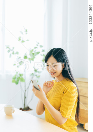 リビングでスマホを見る若い女性 リビングでスマホを見る若い女性 133244364