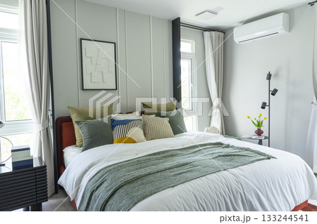 Modern bedroom interior with gray and green bedding. Picture frame on wall. Modern bedroom interior with gray and green bedding. Picture frame on wall. 133244541