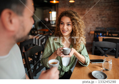 Young couple drinking coffee and talking at a cafe 133245290