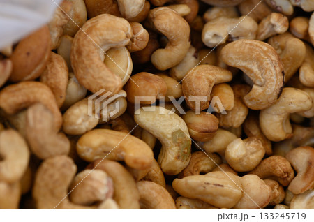 Cashews in a bustling market showcasing their natural curves and colors during a sunny afternoon Cashews in a bustling market showcasing their natural curves and colors during a sunny afternoon 133245719
