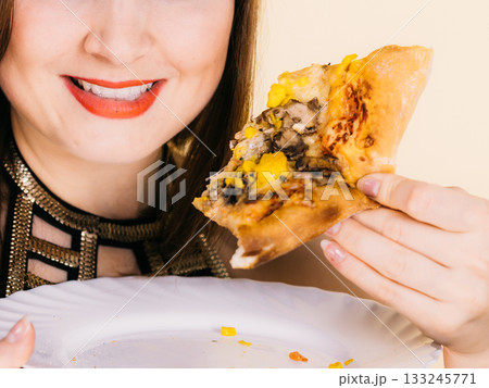 Woman eating hot pizza slice 133245771