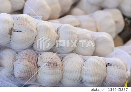 Freshly harvested garlic bundles ready for market in a vibrant farmers market on a sunny day Freshly harvested garlic bundles ready for market in a vibrant farmers market on a sunny day 133245887