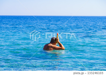 Man with snorkeling tube in sea 133246103