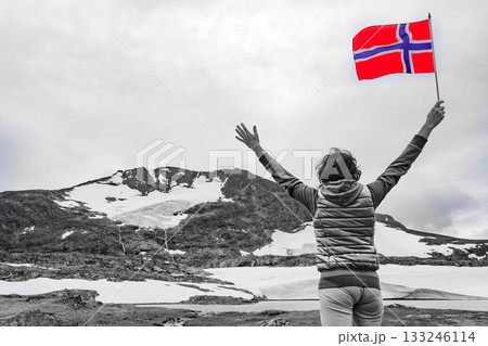 Tourist with norwegian flag in mountains 133246114