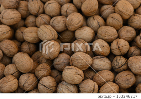 Gathering fresh walnuts in a rustic market during autumn harvest season Gathering fresh walnuts in a rustic market during autumn harvest season 133246217