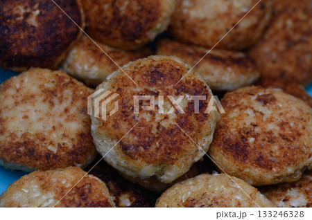Golden brown patties sizzling in a pan on a sunny afternoon Golden brown patties sizzling in a pan on a sunny afternoon 133246328