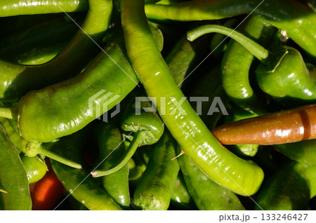 Vibrant green peppers gathered fresh from the market under warm sunlight in a bustling outdoor environment Vibrant green peppers gathered fresh from the market under warm sunlight in a bustling outdoor environment 133246427