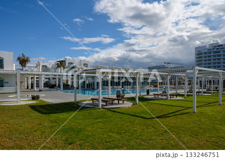 Enjoying tranquility in a beautifully landscaped resort by the poolside on a sunny day 133246751