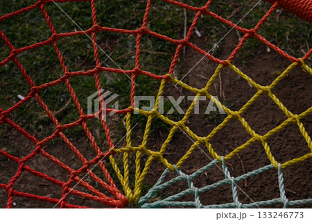 Colorful netting stretches across a grassy field under the afternoon sun Colorful netting stretches across a grassy field under the afternoon sun 133246773