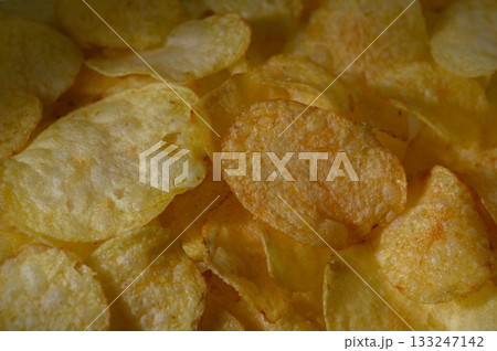 Crunchy golden potato chips arranged in a delicious, mouthwatering pattern ready for snacking 133247142