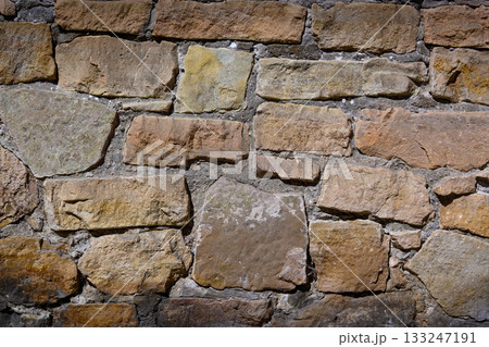 Textured wall of weathered stones creates a rustic charm in an ancient structure Textured wall of weathered stones creates a rustic charm in an ancient structure 133247191
