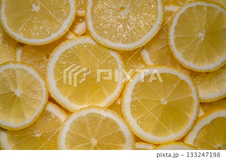 Bright yellow lemon slices create a vibrant and refreshing pattern for culinary inspiration and decor 133247198