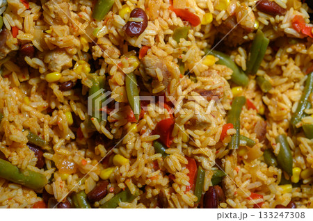 Savory rice dish featuring colorful vegetables and tender chicken cooked in vibrant spices 133247308