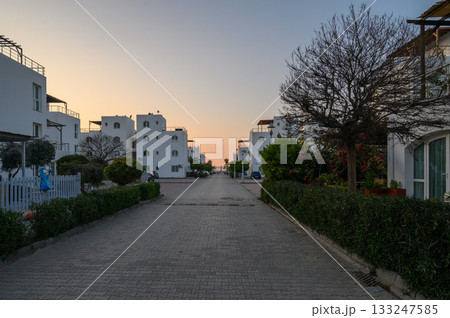 Serene evening stroll through white architecture and lush greenery by the coast Serene evening stroll through white architecture and lush greenery by the coast 133247585