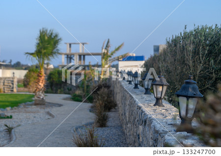 Tranquil pathway adorned with vintage lamps at an evening garden in a coastal town 133247700