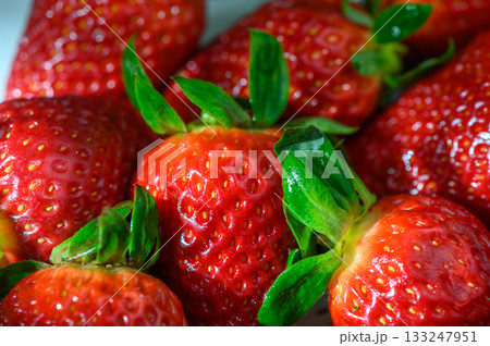 Fresh strawberries glistening under gentle light in a vibrant summer setting 133247951