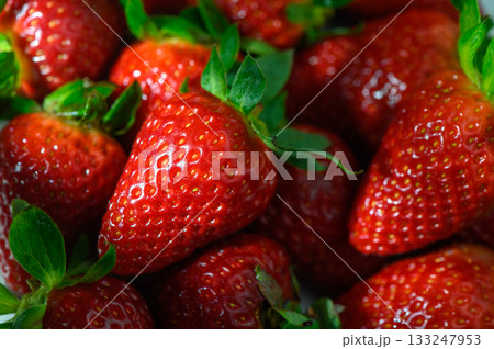 Freshly harvested strawberries glistening under soft natural light in a vibrant summer arrangement 133247953