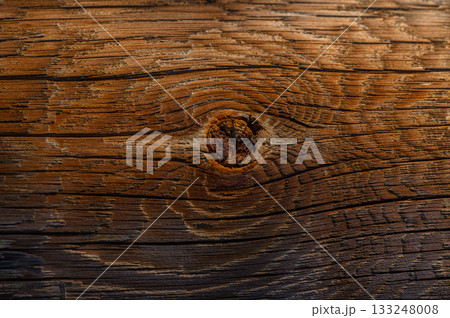 Warm tones of aged wood reveal natural patterns in a rustic setting during golden hour light 133248008
