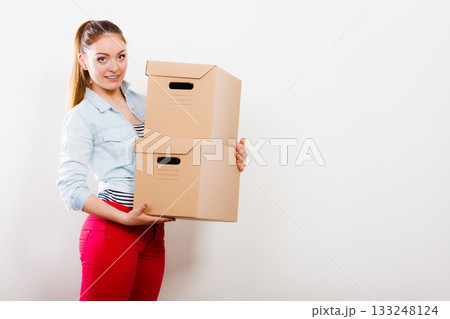 Woman moving into apartment house carrying boxes. 133248124