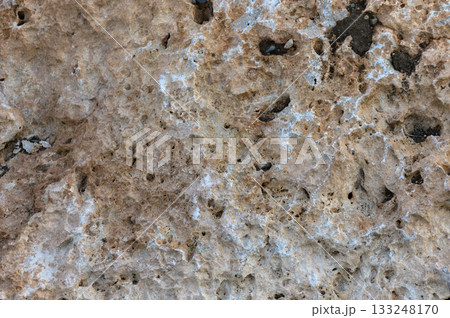 Intricate textures of natural stone revealing earthy tones and unique formations in sunlight Intricate textures of natural stone revealing earthy tones and unique formations in sunlight 133248170