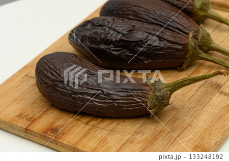 Freshly harvested eggplants on a wooden cutting board ready for culinary delights and healthy meals 133248192