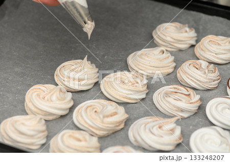 Whipping up sweet delights with meringue cookies in a cozy kitchen Whipping up sweet delights with meringue cookies in a cozy kitchen 133248207