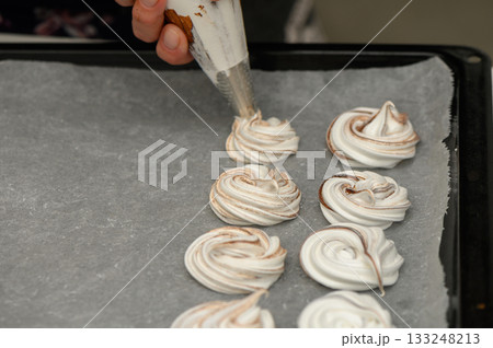 Creating delicate meringue swirls in a cozy kitchen during a baking session Creating delicate meringue swirls in a cozy kitchen during a baking session 133248213