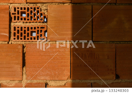 Intricate patterns in a warm-toned brick wall revealing craftsmanship and texture in a construction site Intricate patterns in a warm-toned brick wall revealing craftsmanship and texture in a construction site 133248303