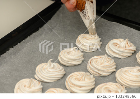Swirling meringue delights crafted with care in a modern kitchen setting 133248366