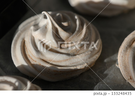 Swirls of sweetness captured in soft meringue delicacies on a baking tray Swirls of sweetness captured in soft meringue delicacies on a baking tray 133248435