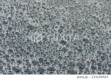 Tranquil bubbles create a mesmerizing surface texture on water at the break of dawn 133248483