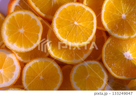 Freshly sliced oranges arranged beautifully on a bright surface highlighting their vibrant color and texture Freshly sliced oranges arranged beautifully on a bright surface highlighting their vibrant color and texture 133249047