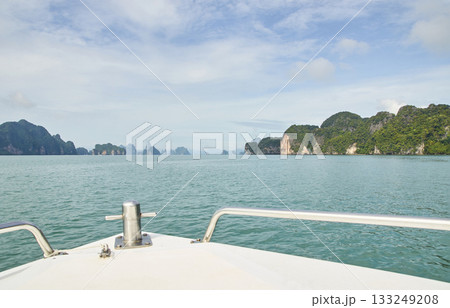 Scenic view from boat in tropical waters with lush islands and clear sky Scenic view from boat in tropical waters with lush islands and clear sky 133249208