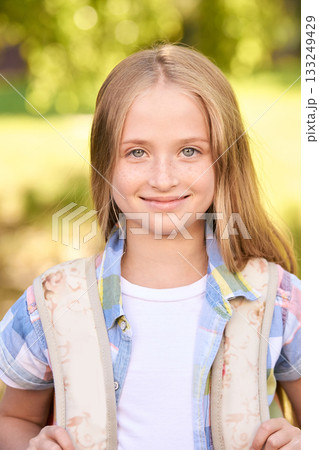 Smiling caucasian young girl outdoors with backpack on sunny day Smiling caucasian young girl outdoors with backpack on sunny day 133249429