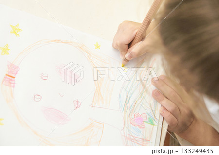 Young caucasian child coloring drawing with pencils 133249435
