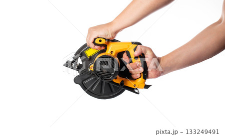 A powerful electric hand-held circular saw in a man's hands, isolated on a white background, close-up. Woodworking tool, industry A powerful electric hand-held circular saw in a man's hands, isolated on a white background, close-up. Woodworking tool, industry 133249491