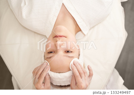 Young caucasian female receiving relaxing facial treatment at spa for skin care Young caucasian female receiving relaxing facial treatment at spa for skin care 133249497