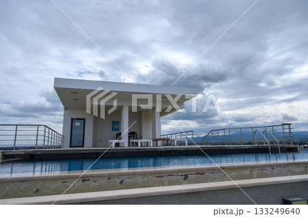 Scenic rooftop poolside retreat with cloudy skies and modern architecture Scenic rooftop poolside retreat with cloudy skies and modern architecture 133249640