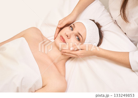 Relaxing spa treatment for young caucasian female with face massage 133249853