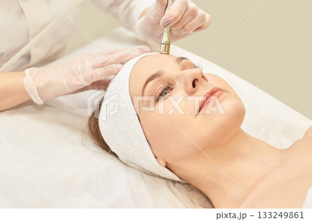 Caucasian female receiving anti-aging microdermabrasion facial treatment at spa Caucasian female receiving anti-aging microdermabrasion facial treatment at spa 133249861