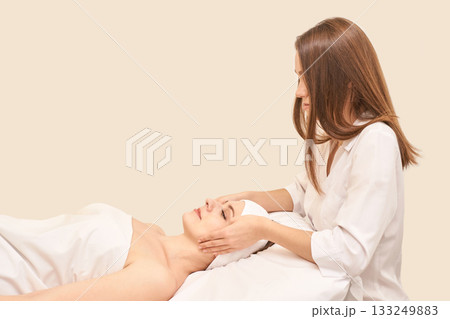 Female caucasian adult receiving relaxing facial massage from professional spa 133249883