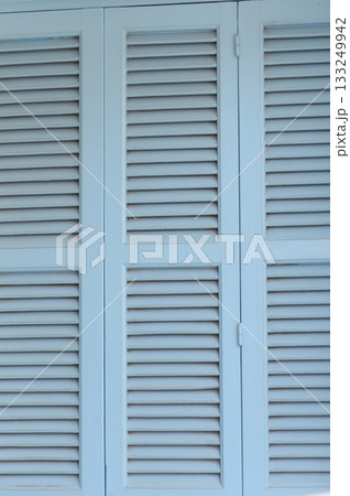 Light blue wooden shutters create a refreshing atmosphere on a sunny day by the coastal villa near the beach Light blue wooden shutters create a refreshing atmosphere on a sunny day by the coastal villa near the beach 133249942