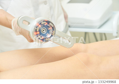 Female caucasian adult receiving knee therapy with modern physiotherapy 133249968