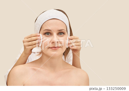 Caucasian female adult receiving facial treatment at spa with relaxed Caucasian female adult receiving facial treatment at spa with relaxed 133250009