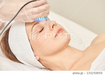 Young caucasian female receiving led light therapy facial treatment in spa Young caucasian female receiving led light therapy facial treatment in spa 133250050